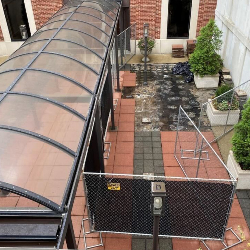 red stone flooring torn up with construction fence